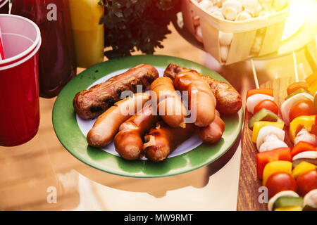 Würstchen draußen am Grill auf dem Teller serviert, gekocht Stockfoto