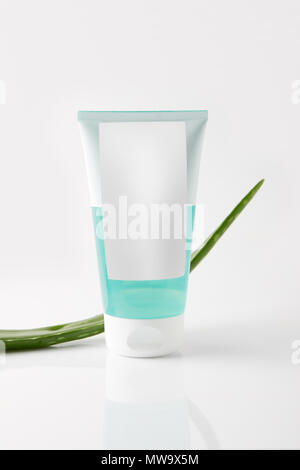 Detailansicht Creme Tube und Aloe Vera Blatt auf weiße Oberfläche Stockfoto