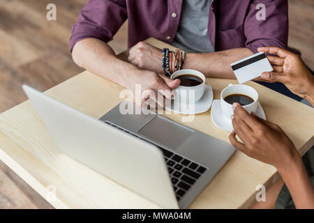 7/8 Schuß von junges Paar mit Kreditkarte Kaffee zu trinken und mit Laptop am Tisch Stockfoto