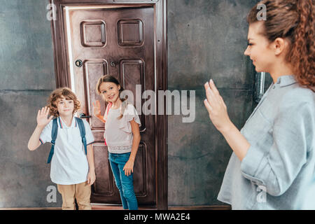 Junge Mutter, ihr süßen kleinen Kinder zur Schule Stockfoto