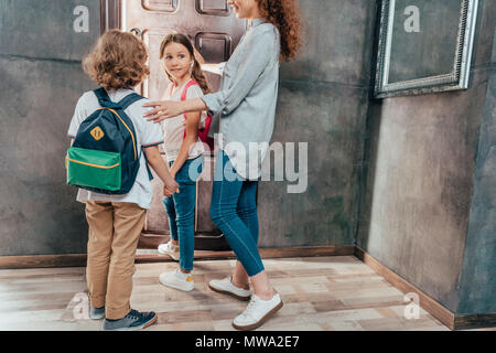 Junge Mutter, ihr süßen kleinen Kinder zur Schule Stockfoto