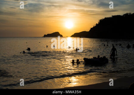 Sonnenuntergang am Strand mit Menschen Stockfoto