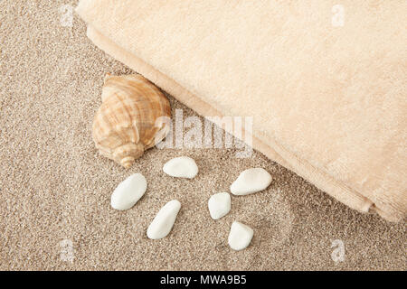 Blick von oben auf die seashell, Meer Steine und Handtücher auf Sand Stockfoto