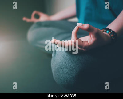 Nahaufnahme der Frau die Hände mit Armbänder der Meditation im Lotussitz im Innenbereich. Gyan Mudra. Yoga, Religion Konzept. Stockfoto