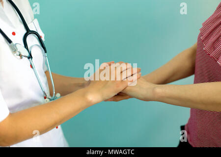 Die Ärztin Hände die Hand des Patienten für Ermutigung und Empathie. Partnerschaft, Vertrauen und medizinische Ethik Konzept. Stockfoto