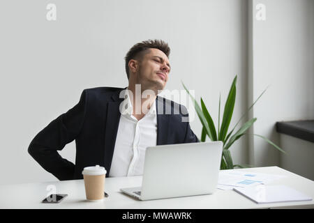 Geschäftsmann berühren schmerzenden Rücken Gefühl Rückenschmerzen nach sedentar Stockfoto