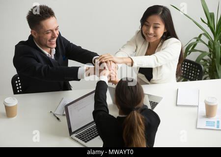 Glücklich lächelnde Team melden sie Hände zusammen in der Gruppe treffen Stockfoto