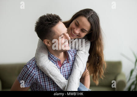 Lächelnde Frau lachend umarmt jungen Mann ihr ein Netzwerk zugreift. Stockfoto