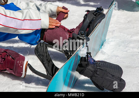 Weibliche snowboarder trägt Snowboardausrüstung Stockfoto