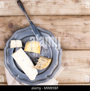 Auf der Platte sind verschiedene Käse für die Partei. Vintage Foto. Holz- Hintergrund. Platz kopieren Stockfoto