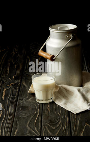 Milch in Glas Aluminium kann einen Sack auf schwarzem Holz- Oberfläche Stockfoto