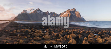 Schwarzen Sandstrand, bewachsene Steine, Berge, und Eystrahorn Klifatindur Kambhorn, landspitze Stokksnes, massiv Klifatindur Stockfoto