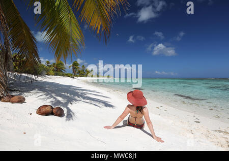 Frau sitzt auf einem tropischen Strand Stockfoto