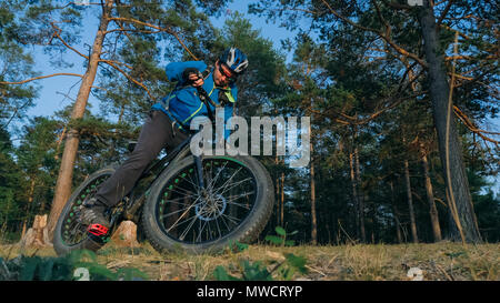 Fat bike auch fatbike oder Fat Tire Bike im Sommer Reiten im Wald. Der Kerl, Fahrten mit dem Fahrrad auf den Waldboden. Es geht in einer kontrollierten Sk Stockfoto