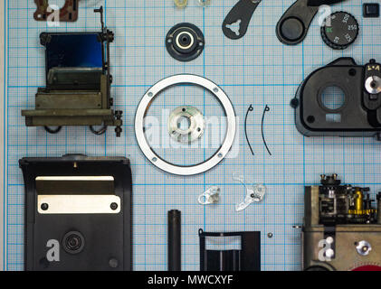 Teile sind vollständig demontiert alten retro Film SLR Kamera auf Millimeterpapier, close-up Stockfoto