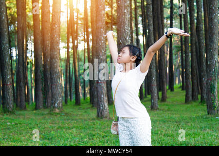 Asien teenage fröhlich in Wald Hintergrund viele Baum mit kopieren. Weiche flare Sonnenlicht. Stockfoto