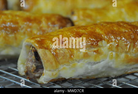 Schweinefleisch und Fenchel Würstchen, Brötchen, heiß aus dem Ofen und Kühlung für den Verkauf in einem Cafe Stockfoto