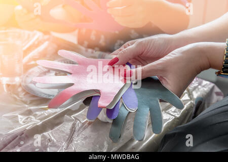 Einer Frau mit einem Papier - Der kleine Kinder Symbole Ausschneiden. Der Lehrer ist mit Kindern engagiert. Ausbildung. Stockfoto