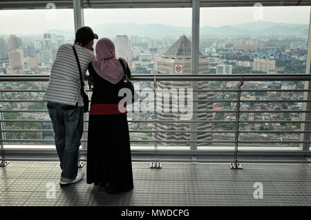 Muslimische Paare Beobachten der Stadt Kuala Lumpur aus der Petronas Twin Towers Skybridge, Malaysia Stockfoto