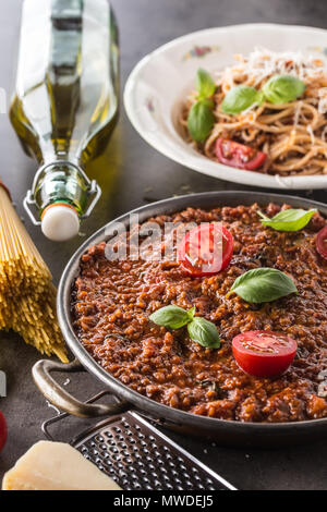 Klassische italienische Sauce Bolognese mit Zutaten Nudeln spaghetti Olivenöl Tomaten, Basilikum und Parmesan. Stockfoto