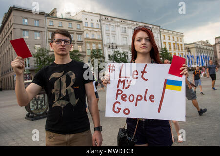 Die ukrainer halten rote Karten während eines Protestes die Freilassung der Ukrainischen Filmemacher und Schriftsteller, Oleg Sentsov am Hauptplatz in Krakau. Oleg Sentsov wurde durch ein russisches Gericht am 25. August 2015 zu 20 Jahre für die Planung eines terroristischen Angriffs auf die Krim Halbinsel im Anhang durch Russland im April 2014 verurteilt. Stockfoto