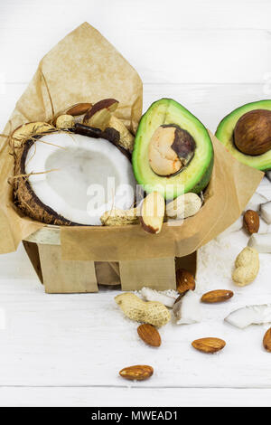 Frische, leckere Kokosnuss mit Avocado auf einer hölzernen weißen Hintergrund, lecker Stockfoto