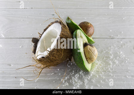 Frische, leckere Kokosnuss mit Avocado auf einer hölzernen weißen Hintergrund, lecker Stockfoto