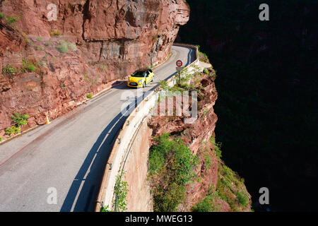 LUFTAUFNAHME von einem 6-Meter-Mast. Sportwagen auf einer schmalen Straße in einem tiefen Canyon. Gorges du Cians, Hinterland der französischen Riviera, Frankreich. Stockfoto