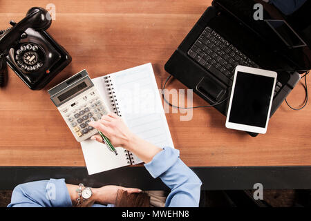 Sekretär Berechnungen auf dem Rechner, Ansicht von oben auf dem Schreibtisch Stockfoto