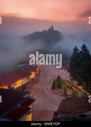 Super schöne Aussicht auf Tsarevets Festung in Veliko Tarnovo, Bulgarien an einem nebligen Sonnenaufgang im Sommer. Stockfoto