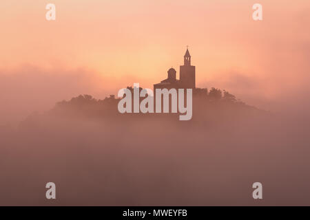 Super schöne Aussicht auf Tsarevets Festung in Veliko Tarnovo, Bulgarien an einem nebligen Sonnenaufgang im Sommer. Stockfoto