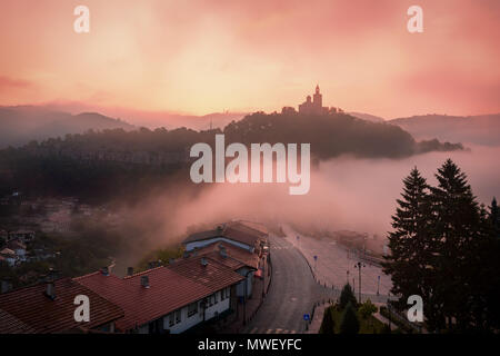 Super schöne Aussicht auf Tsarevets Festung in Veliko Tarnovo, Bulgarien an einem nebligen Sonnenaufgang im Sommer. Stockfoto