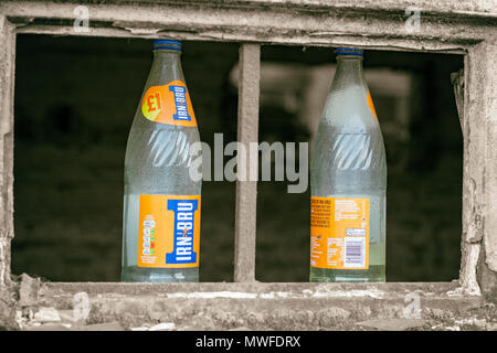 Irn Bru Flaschen auf eine zerbrochene Fensterrahmen Stockfoto