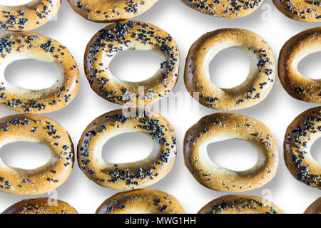 Ein Foto von Bagels mit Mohn. Bagels arrangiert als Muster. Isoliert Foto auf dem weißen Hintergrund für Site über Küche, Lebensmittel, Traditionen. Stockfoto