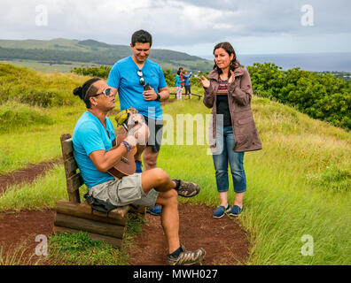 Improvisierte Gitarre spielen Musik von lokalen Polynesischer Mann mit haarknoten, mit jungen Paar Publikum und Frau klatschen, Puna Pau Steinbruch, Osterinsel Stockfoto