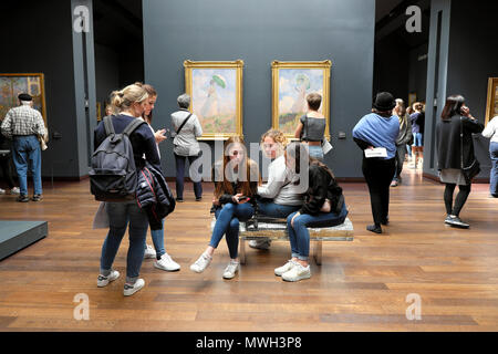 Junge Frauen sitzt auf der Bank sprechen und die Leute, die das Musée d'Orsay Kunst Galerie & Monet die Frau mit Sonnenschirm 1886 Paris Frankreich KATHY DEWITT Stockfoto