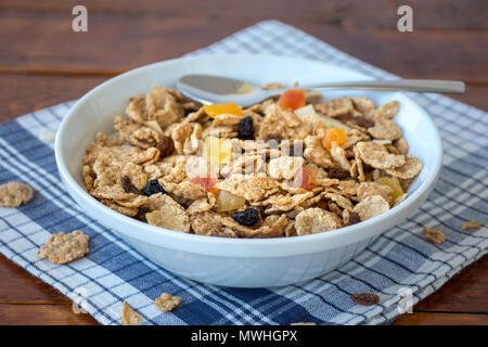 Eine Schüssel voll mit Müsli Müsli mit Löffel über eine hölzerne Tabelle Stockfoto
