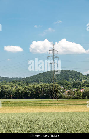 Strommast in der deutschen Landschaft mit Wäldern, Feldern und Wiesen Stockfoto