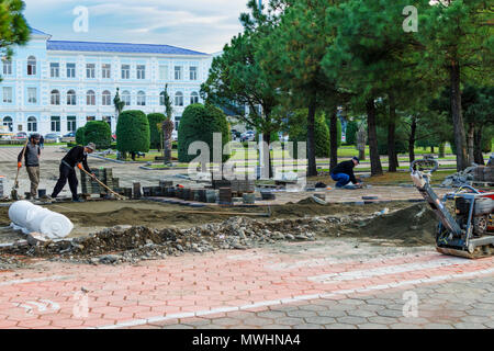 Batumi, Georgien, 2017-11-28: Die Bauherren neue Pflasterung Platte lag auf Fußgängerzone, Gehweg unter Park in der Stadt. Verwendung von Handwerkzeugen für die Nivellierung des Bodens Stockfoto