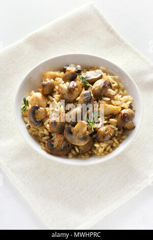 Leckeres Risotto mit Pilzen und Stücke von Hähnchenfleisch in Schüssel. Ansicht von oben Stockfoto
