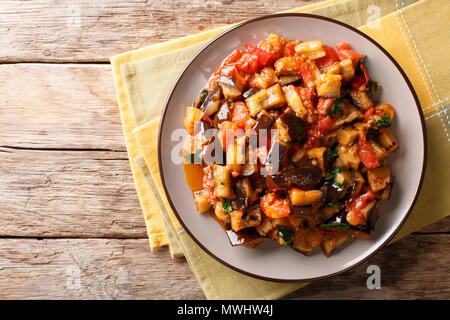 Lecker Snack aus gebratenen Auberginen, Tomaten und Knoblauch mit Gewürzen close-up auf einem Teller. horizontal oben Ansicht von oben Stockfoto