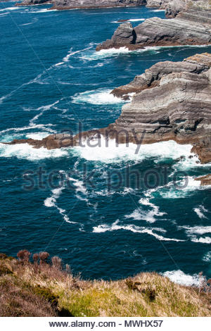 Wellen des Atlantiks Schaumstoff Weiß gegen schroffe Felsen im County Kerry an der Südwestküste von Irland Stockfoto