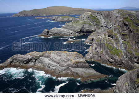 Wellen des Atlantiks Schaumstoff Weiß gegen schroffe Felsen im County Kerry an der Südwestküste von Irland Stockfoto