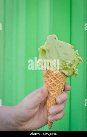 Waffel Kegel mit Matcha Eis gegen Grüner Hintergrund Stockfoto