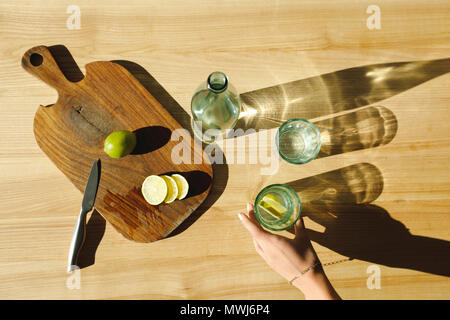 7/8 Bild der Frau mit Glas Limonade auf hölzernen Tisch Stockfoto