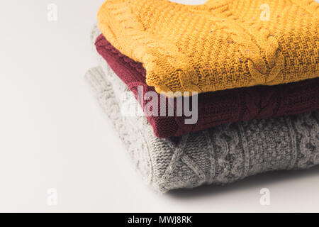 Stapel von warmen gemütlichen Pullover, isoliert auf weißem Stockfoto