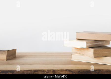 Stapel alter Bücher auf Holztisch auf Weiß Stockfoto