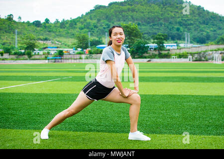 Mädchen stretching auf dem Fußballfeld vor dem Joggen Stockfoto