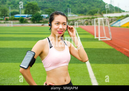 Mädchen setzen moderne Technik joggen Ausrüstung Stockfoto