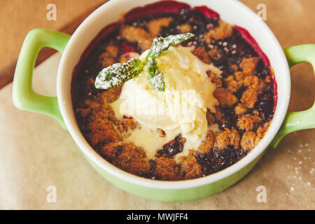 Crumble serviert im Topf mit Eis Stockfoto